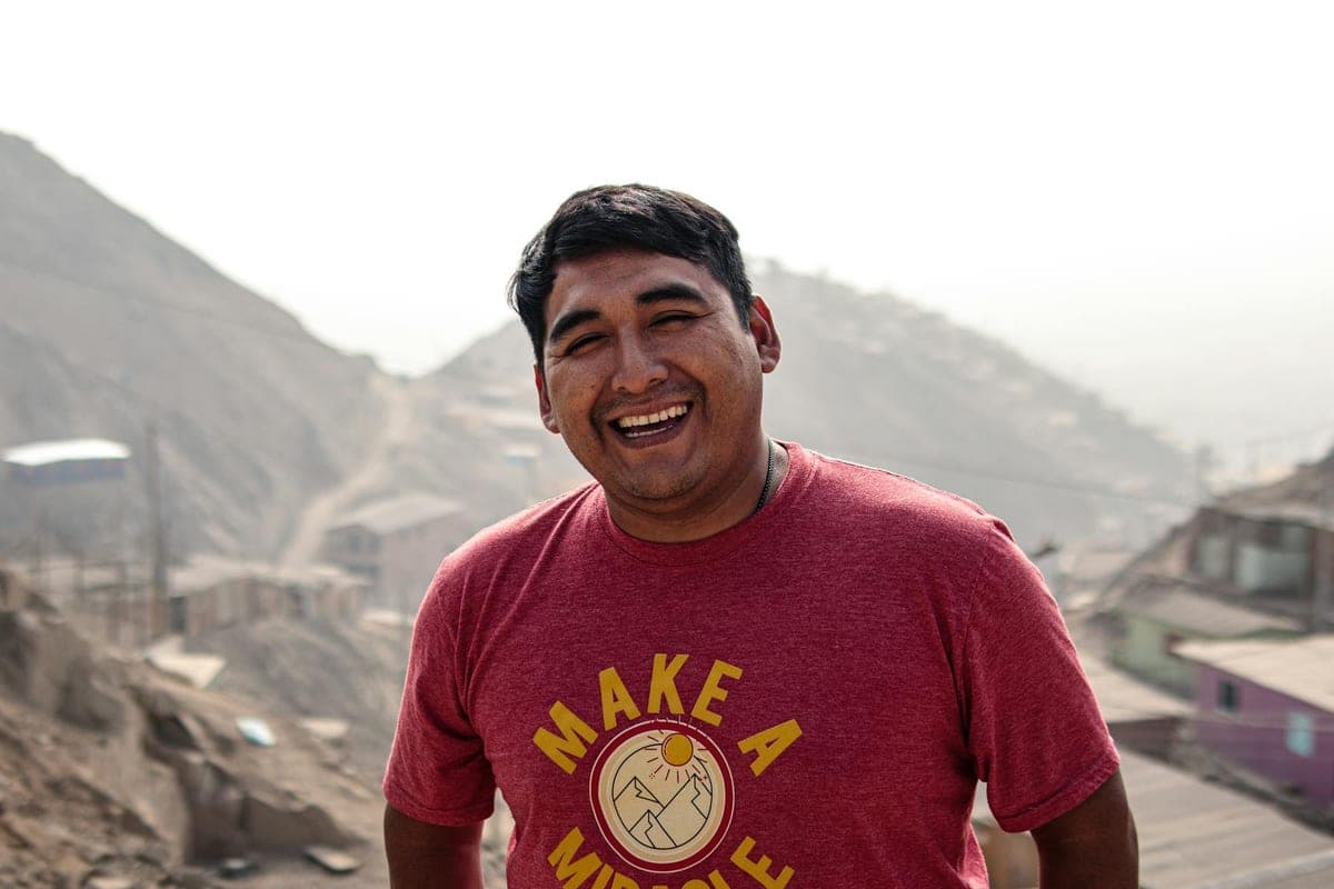 Smiling man in a red shirt with his face fully visible.